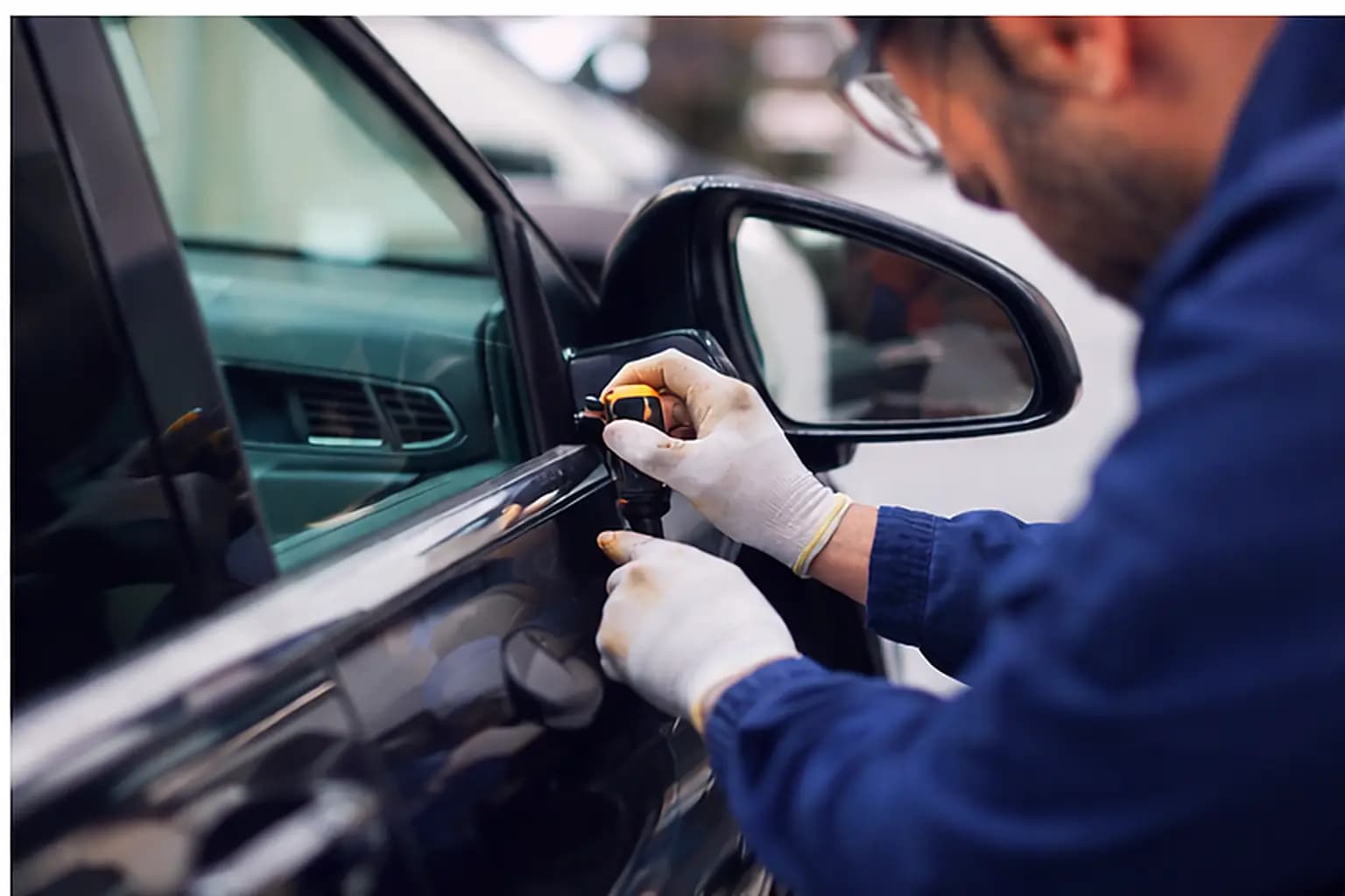 Servis retrovizora – majstor popravlja bočni retrovizor na vratima automobila